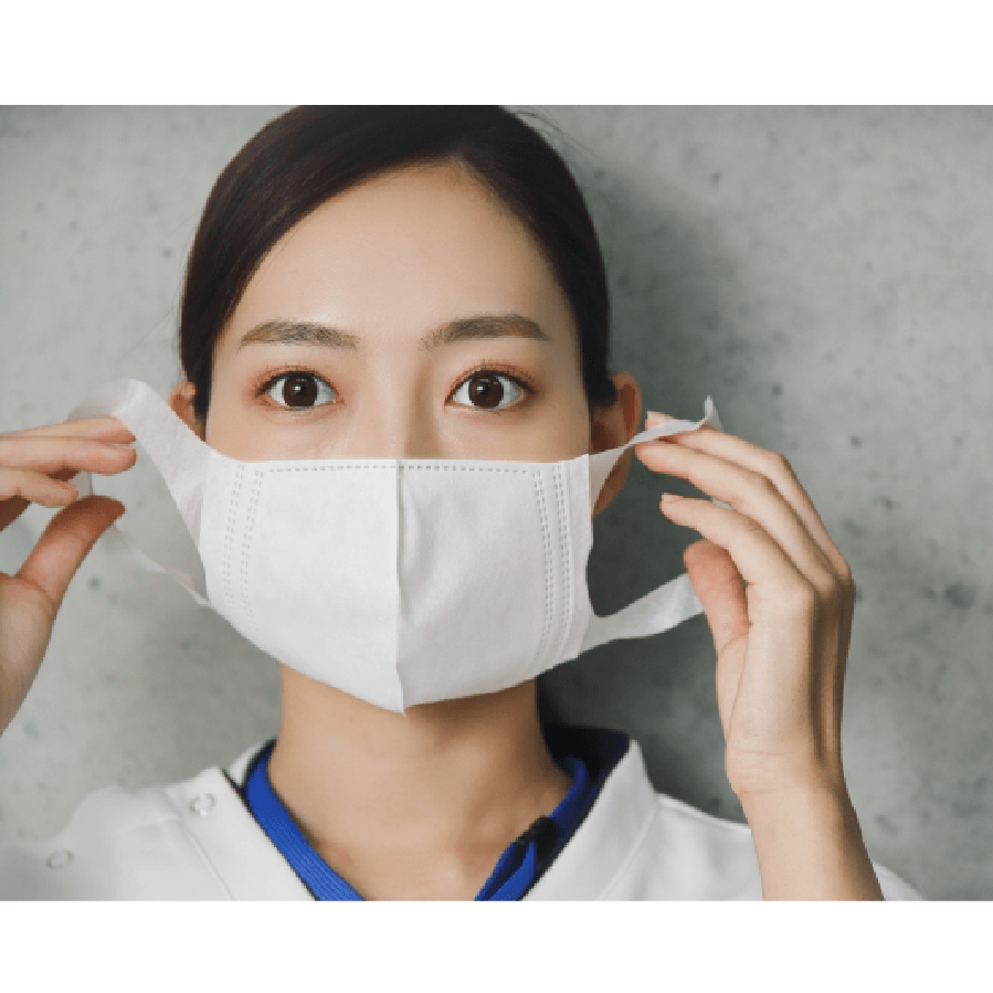 真剣な表情でマスクをつける医療従事者の女性